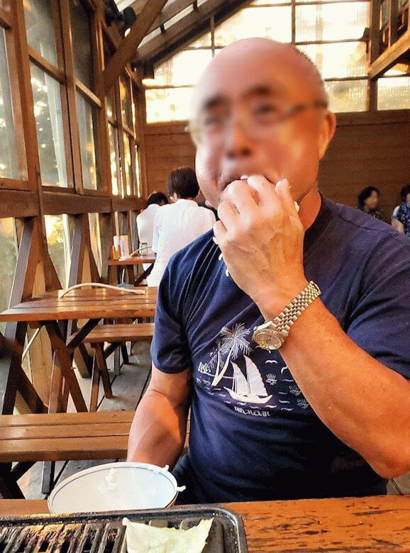 阿蘇鶴温泉ロッジ村で夕食にバーベキュー時にご飯粒だらけの手を舐めるオジサンの姿-1
