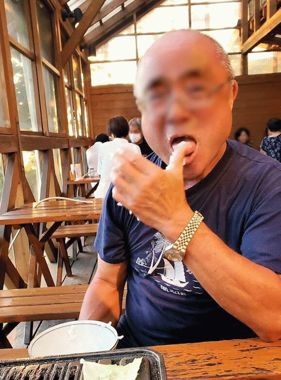 阿蘇鶴温泉ロッジ村で夕食にバーベキュー時にご飯粒だらけの手を舐めるオジサンの姿-2