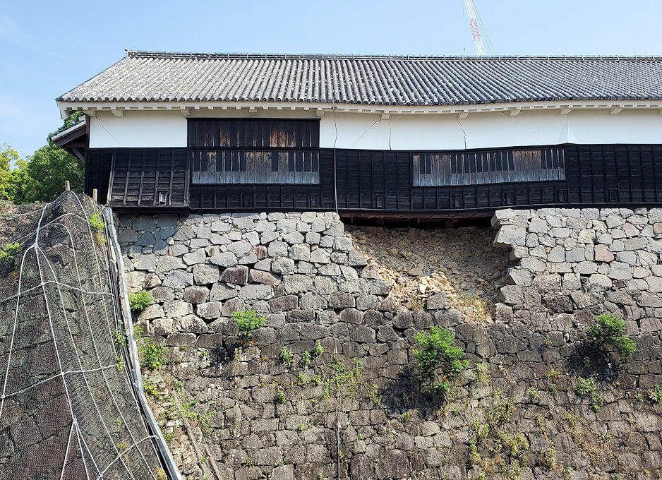 熊本城本丸近くの有料ゾーンから崩れた石垣とその上に残る櫓を見る