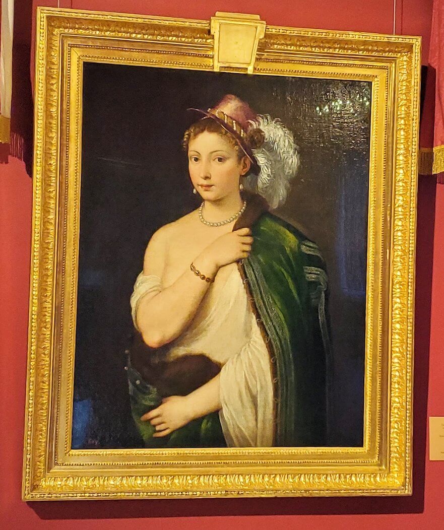 『羽飾りの帽子をかぶった若い女性の肖像』 by ティツィアーノ・ヴェチェッリオの絵画