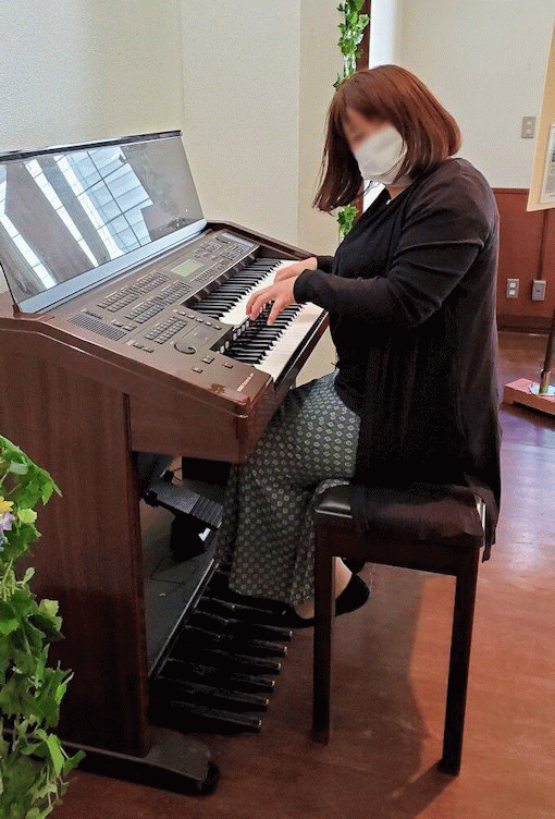 さっぽろ羊ヶ丘展望台にあるクラークチャペル内のピアノを弾く女性