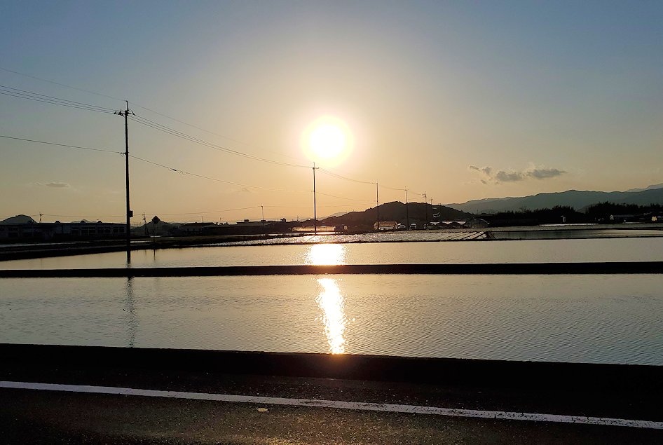 高知県南国市　土佐で田んぼの水面に反射する夕陽の景色