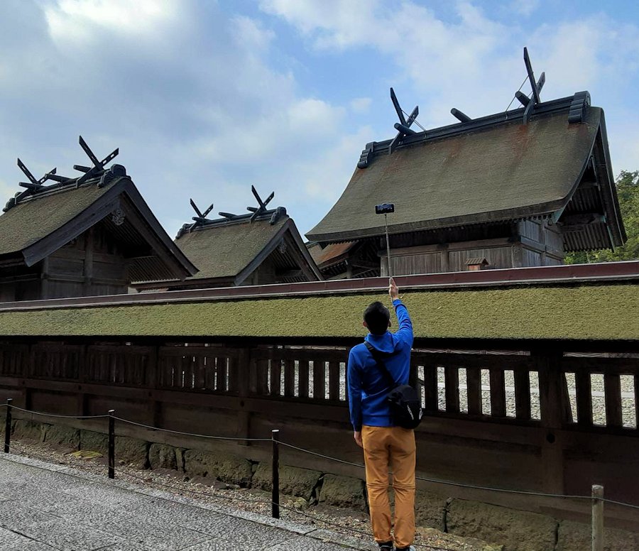 島根県　出雲大社　本殿の写真を撮影する男