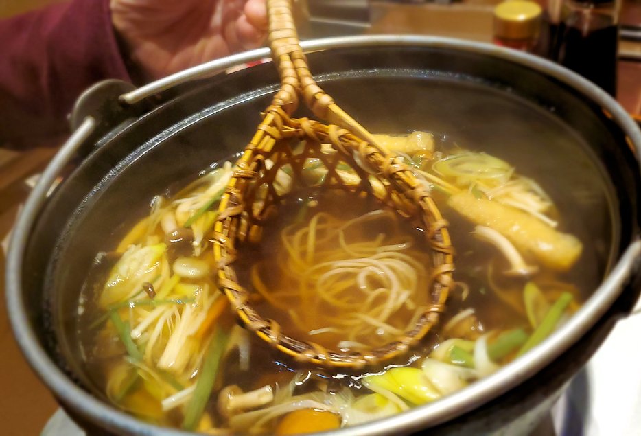 夜の松本市内　「みよ田 松本店」　蕎麦をとうじカゴに入れて鍋に浸す