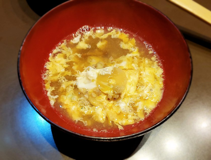 夜の松本市内　「みよ田 松本店」　そば米雑炊を茶碗に入れる