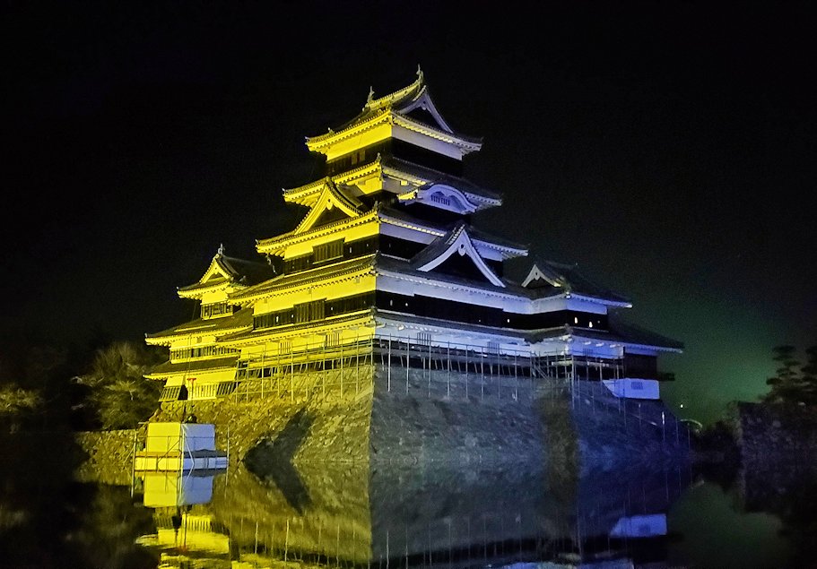 夜の松本城でライトアップされる天守