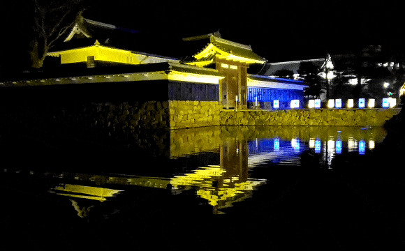 夜の松本城　ライトアップされた黒門　動く水面